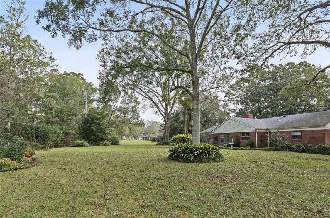 Our Backyad, a red brick house on the far right with lawn and gardens
